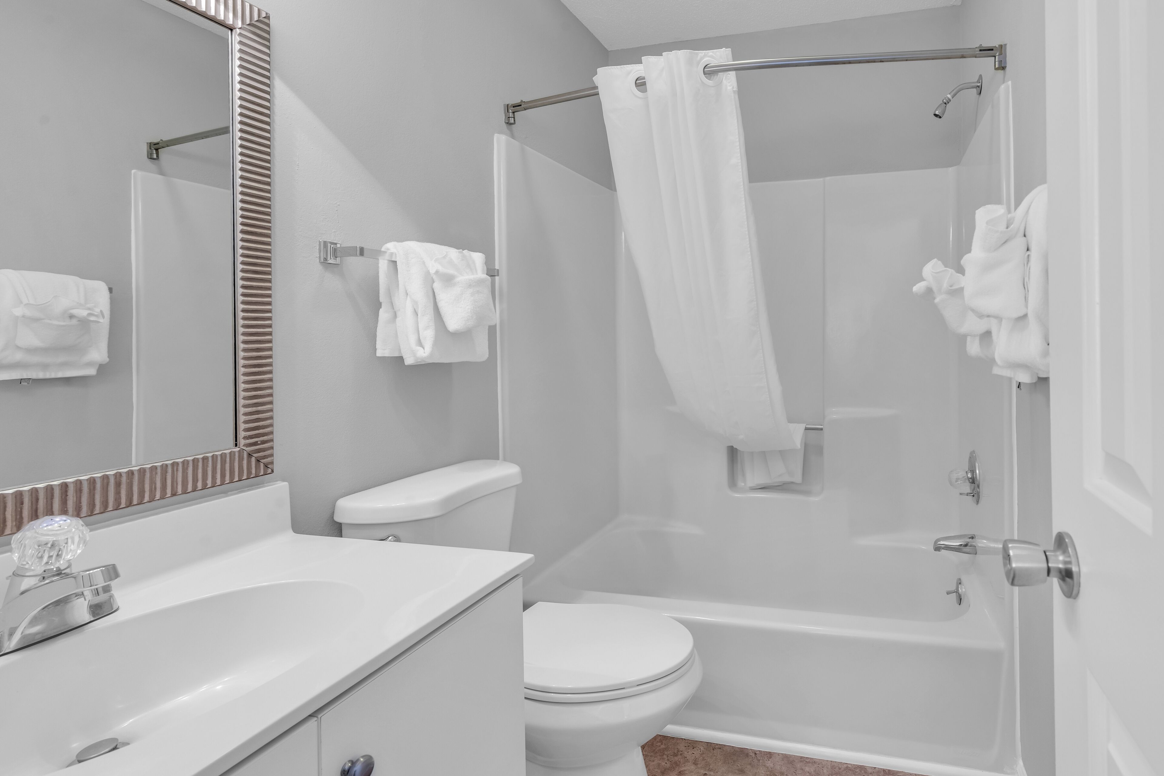 A modern bathroom with a white sink, toilet, and bathtub.