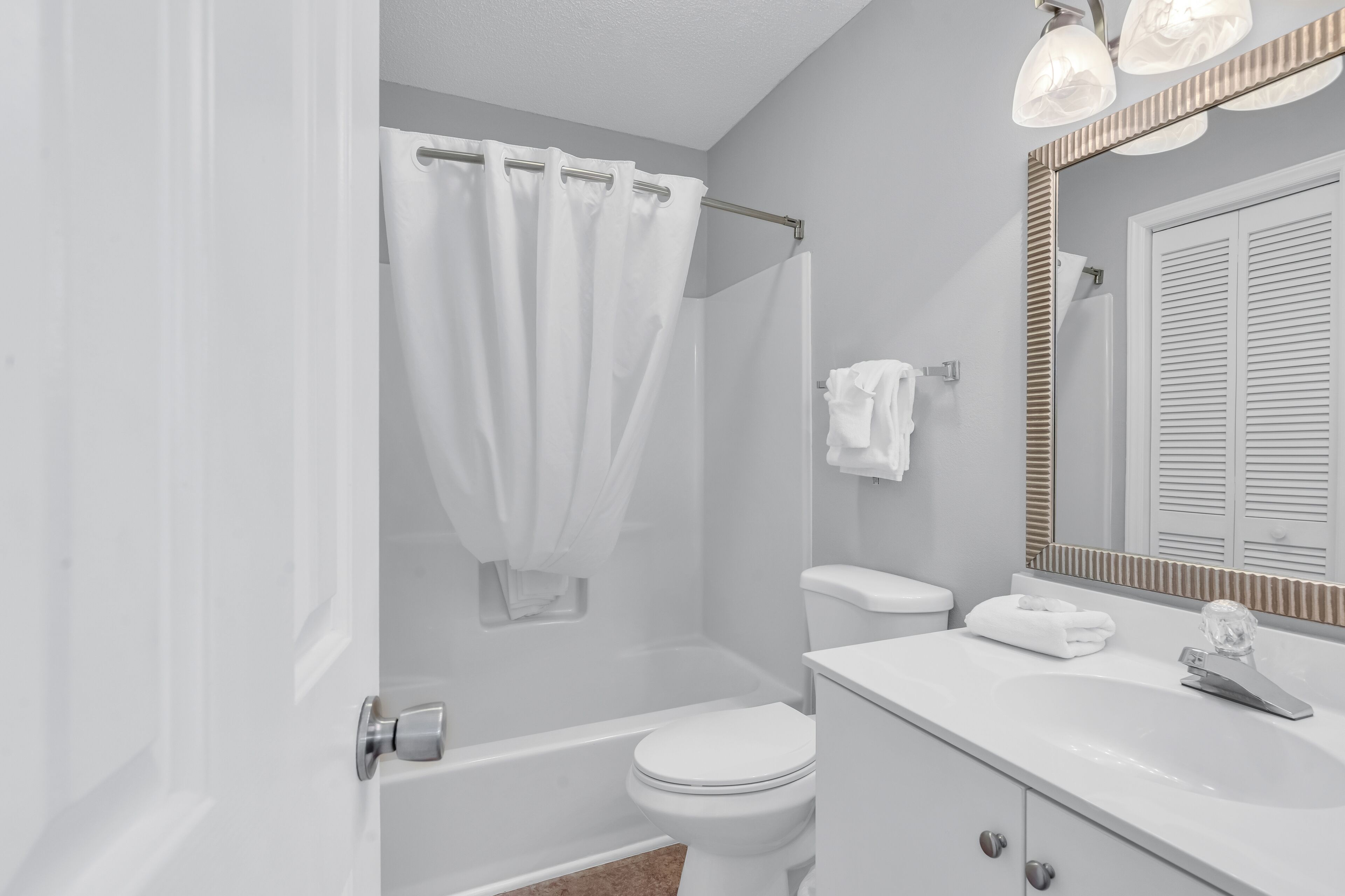 A bathroom with a bathtub, toilet, and sink.