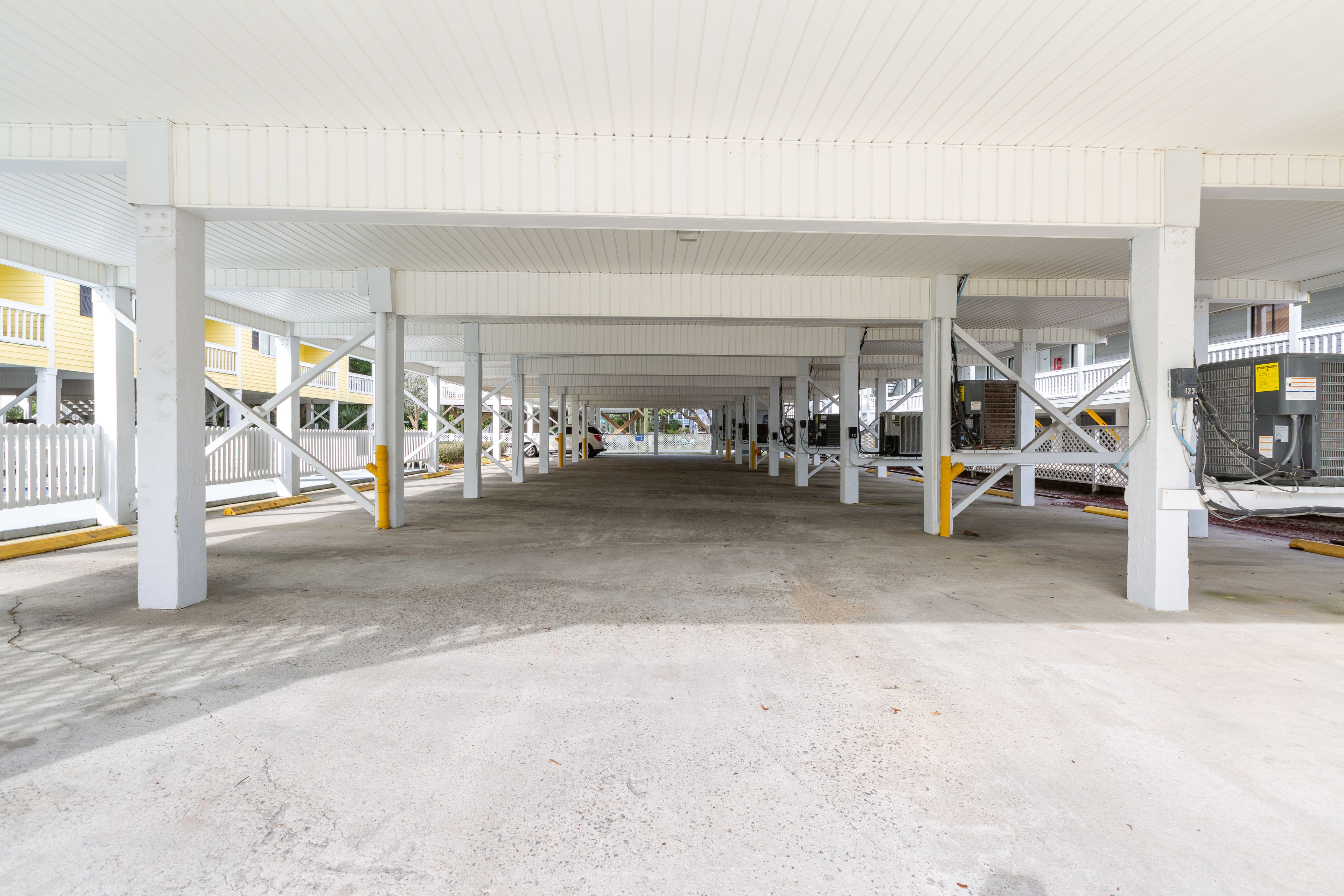 A spacious indoor area with a high ceiling and white structural beams.