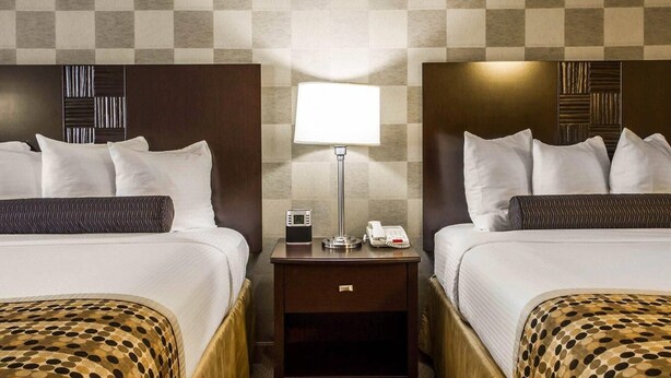 A hotel room with two beds, a nightstand with a lamp, and a digital clock. - Hotel Med Park, an Ascend Collection Hotel (Sacramento)