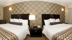 A hotel room with two beds, a checkered wall, and a nightstand with a lamp and phone. - Hotel Med Park, an Ascend Collection Hotel (Sacramento)