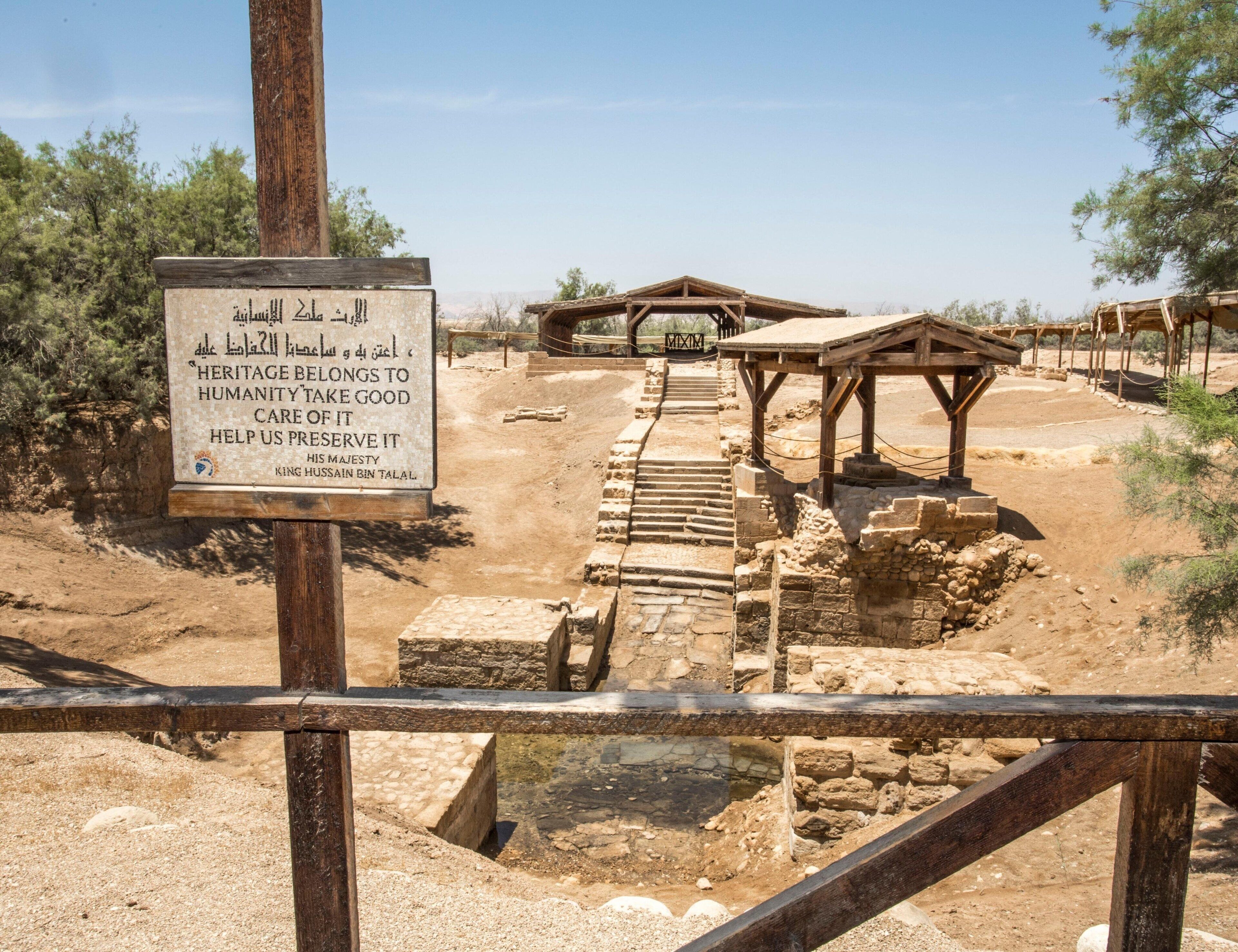 Un lugar histórico con construcciones de piedra y una pasarela de madera.