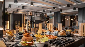 A restaurant counter with a variety of food items including burgers, fries, and pizza.