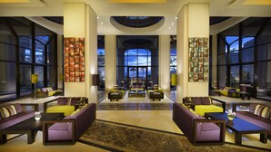 A spacious lobby with high ceilings, large windows, and modern seating arrangements.