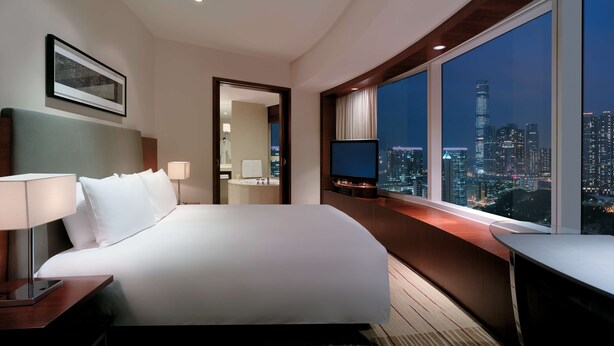 A hotel room with a large bed, a TV, a desk, and a city view. - Hyatt Regency Hong Kong, Tsim Sha Tsui (Kowloon)