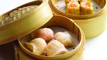 Two bamboo steamers with food inside, one open and one closed.