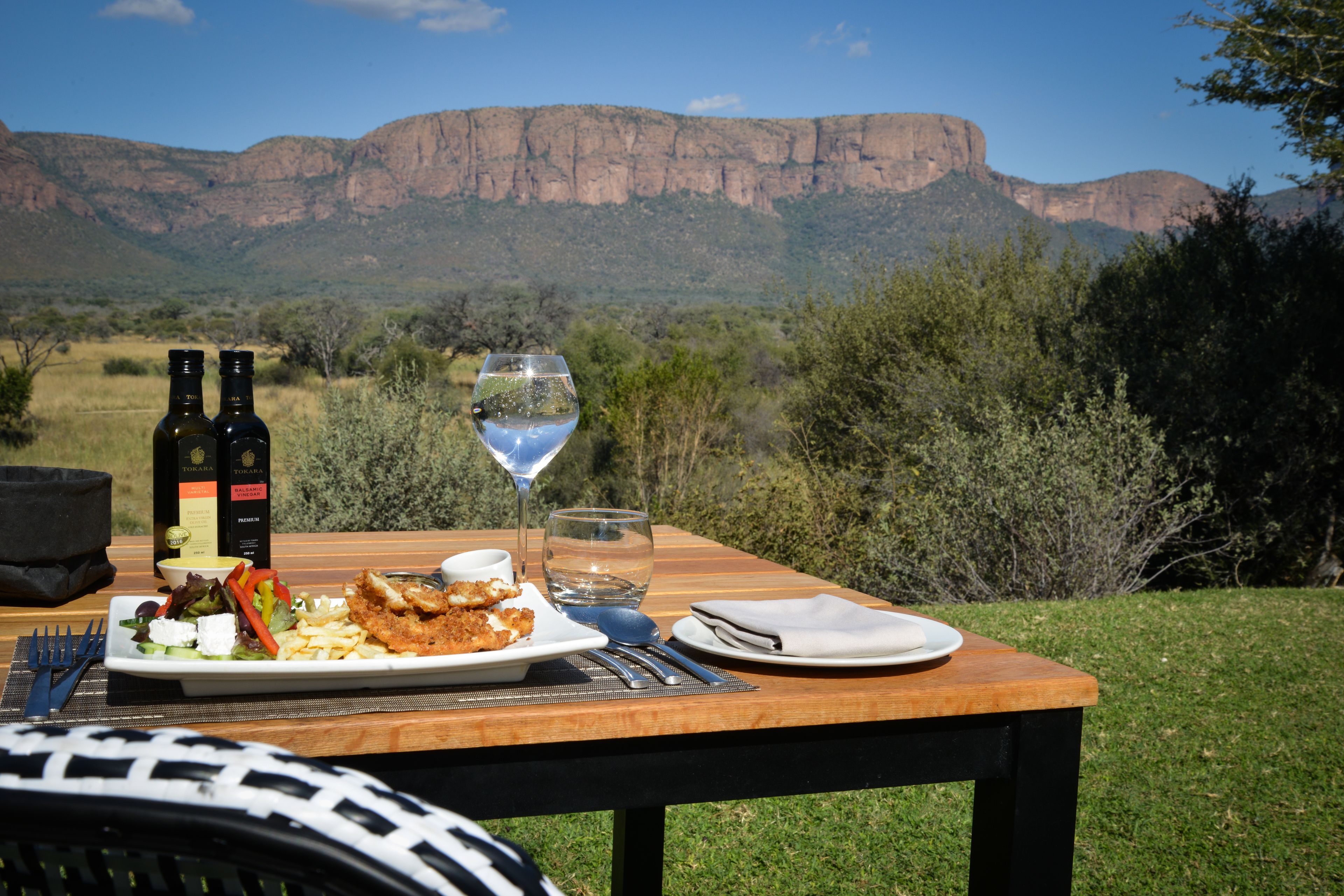 Une table à manger installée à l’extérieur, offrant une vue sur une chaîne de montagnes.