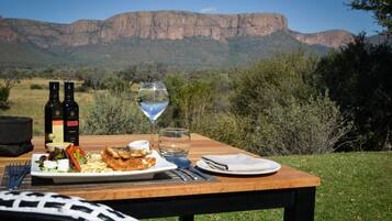 Une table à manger installée à l’extérieur, offrant une vue sur une chaîne de montagnes.