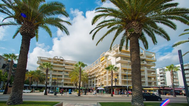 A multi-story hotel with balconies, palm trees, and a pedestrian walkway. - Ona Suites Salou (Salou)