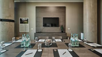 A conference room with a large table, water bottles, and a television screen.