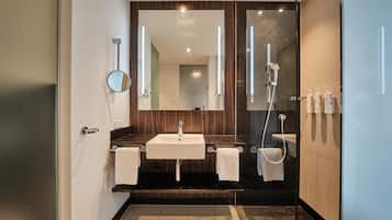 Un baño moderno con lavamanos doble, un espejo grande, cabina de ducha con mampara de vidrio y un perchero para toallas.
