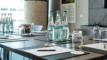 A conference table with water bottles, glassware, and documents.