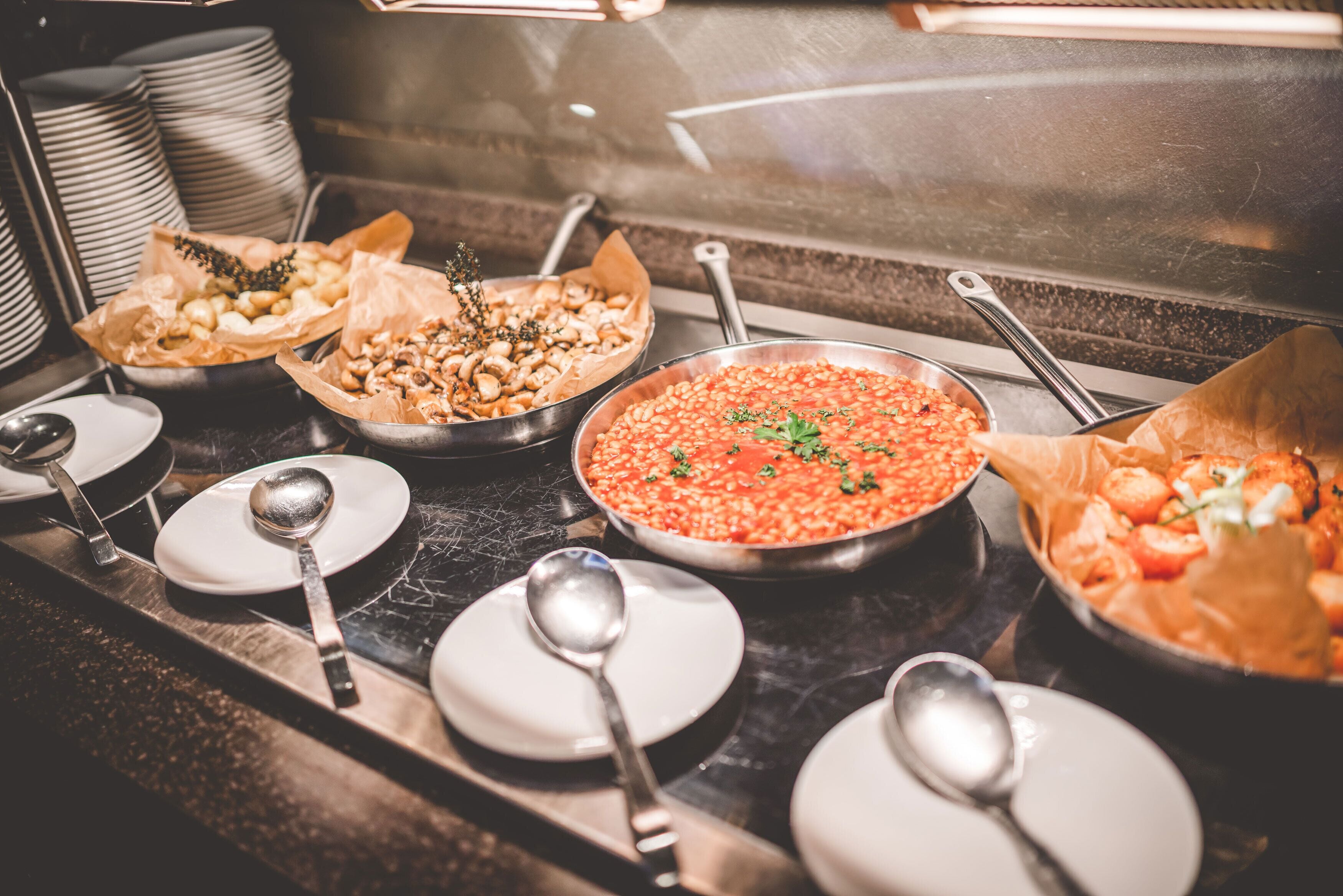 A buffet with various dishes, including a large pot of red beans, a bowl of nuts, and a tray of shrimp.
