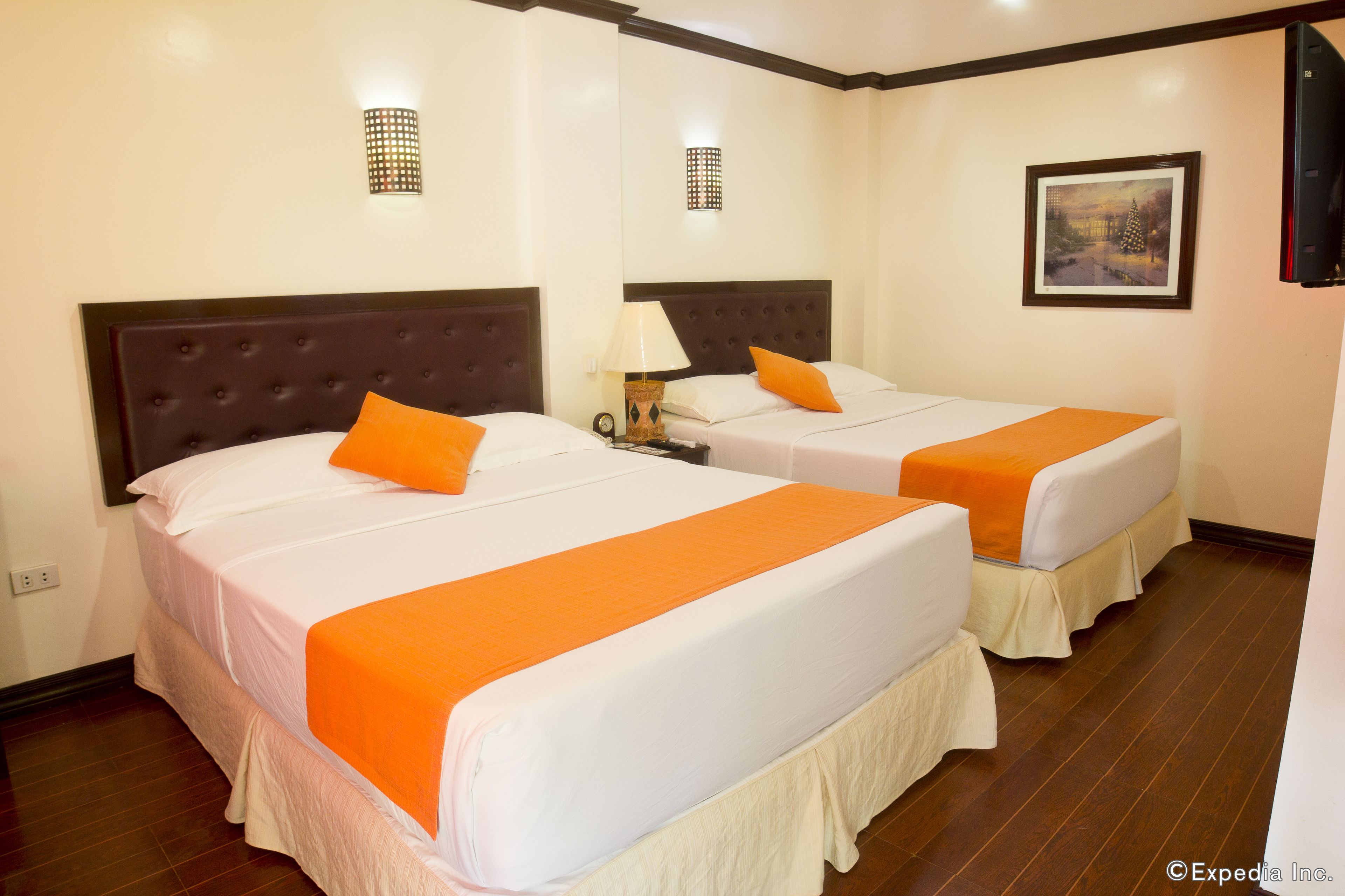 Two single beds with orange bedspreads in a hotel room.