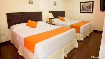Two single beds with orange bedspreads in a hotel room.