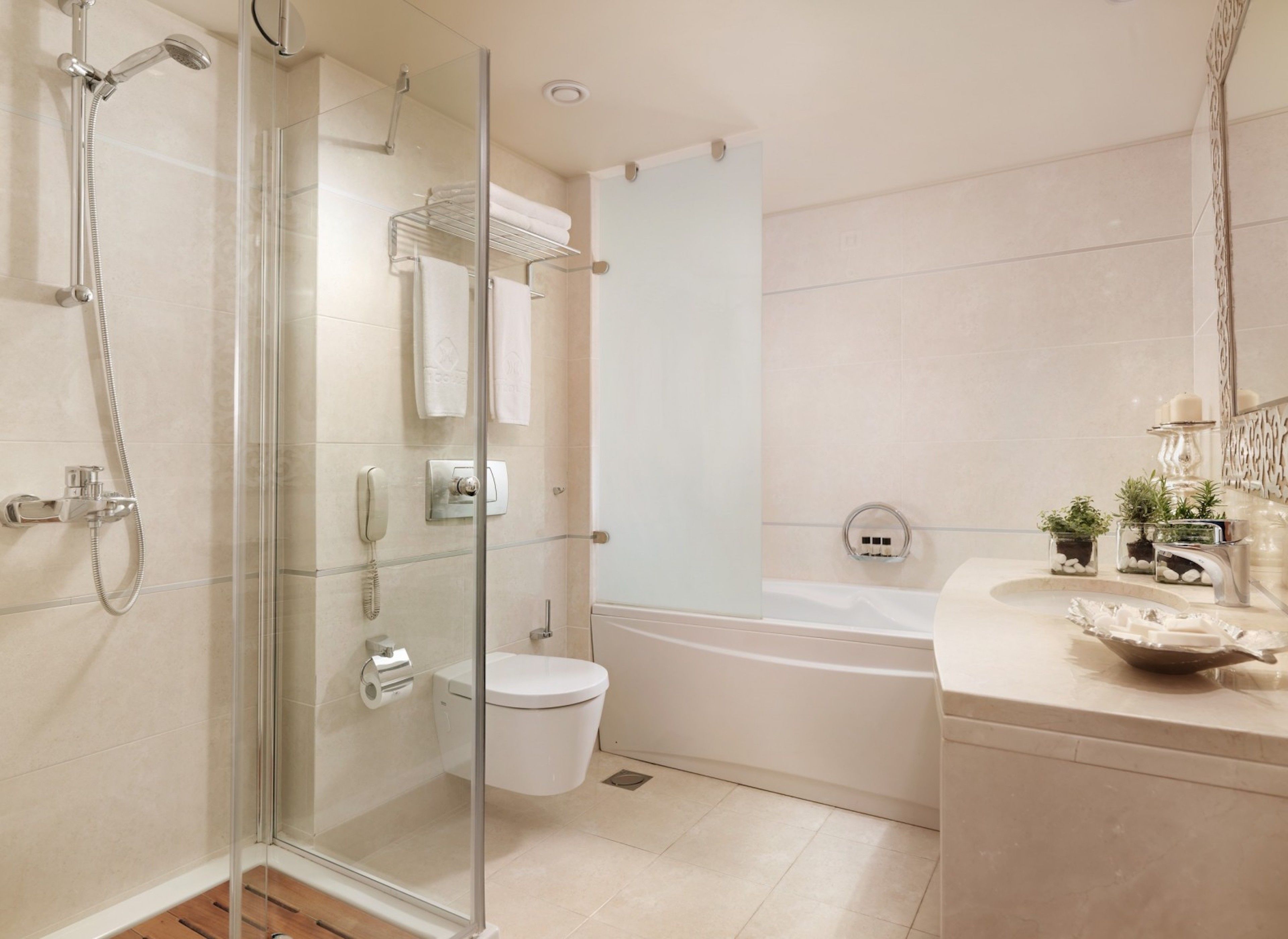 Ein modernes Badezimmer mit einer Duschkabine, einer Toilette und einer Badewanne.