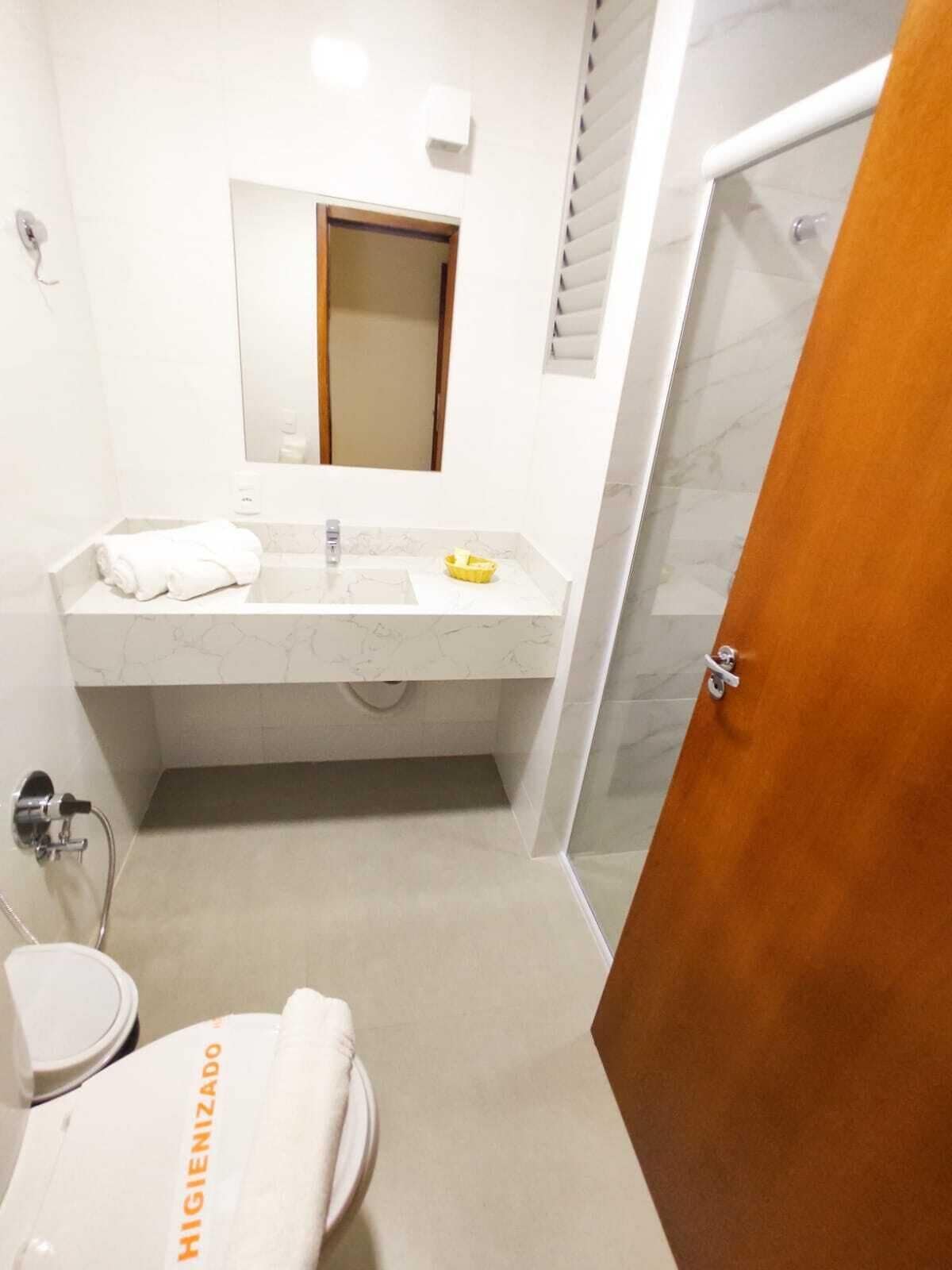 Un baño moderno con lavamanos de mármol, espejo y zona de ducha.