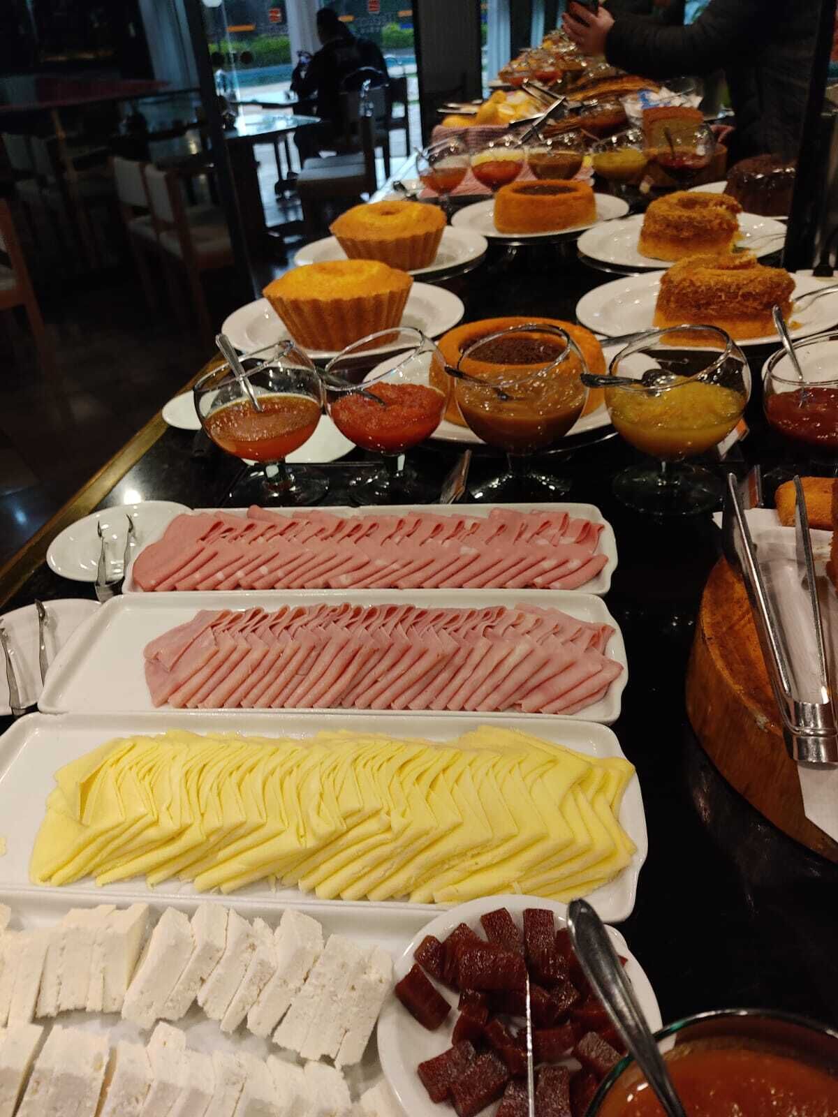 A buffet with various food items including meats, cheeses, and desserts.