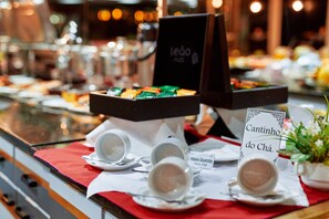 A buffet setup with various food items and a coffee station.