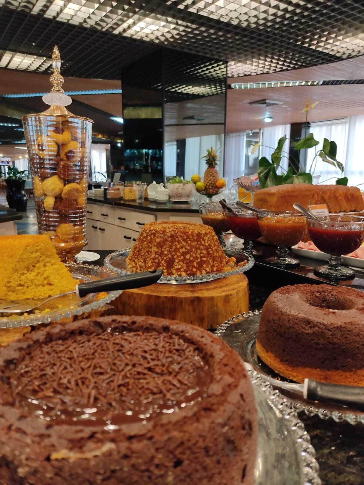 Un bufé con diversos postres, incluyendo pasteles y un recipiente de vidrio con nueces.