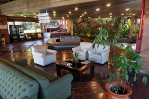 A lobby with a seating area, a reception desk, and a staircase leading to upper floors. - Hotel Colonial Iguaçu (Foz do Iguaçu)