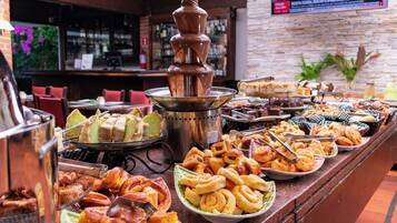 A buffet with various baked goods and pastries.