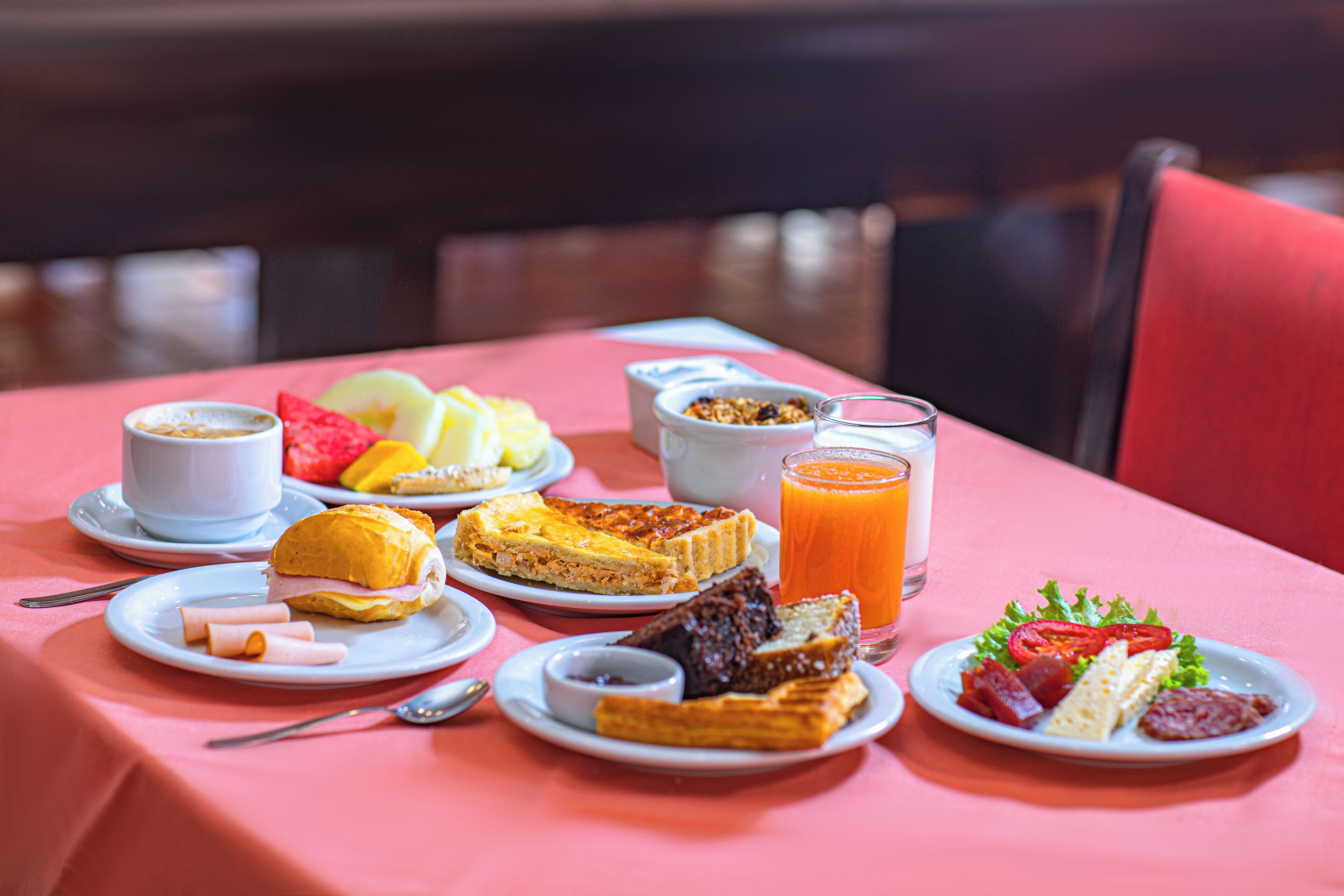 A breakfast table with various dishes including toast, eggs, and fruit.