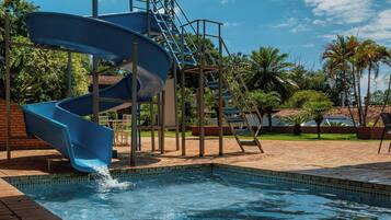 A blue water slide with a pool at the bottom.