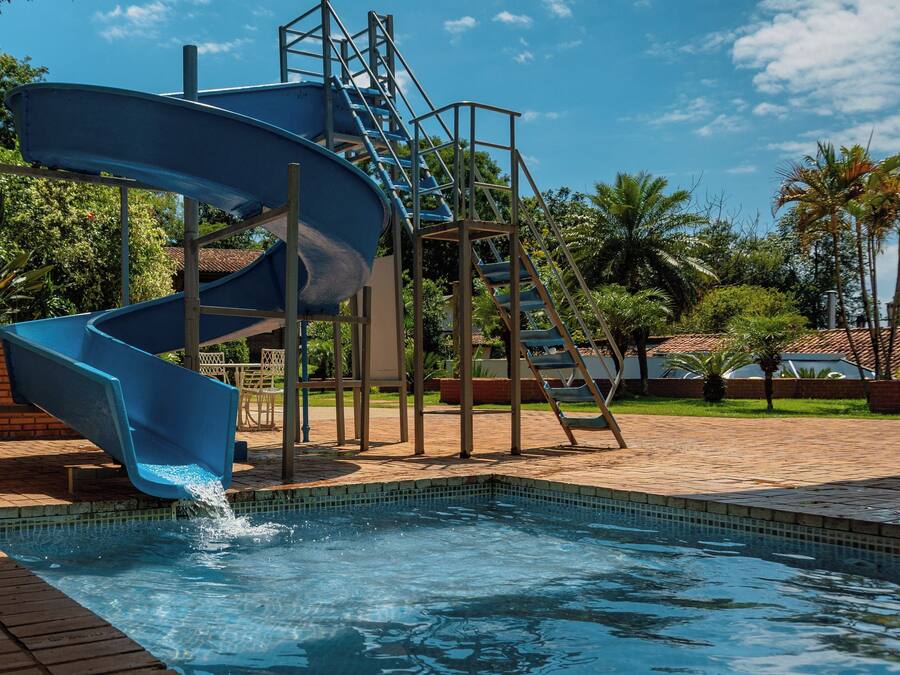 A blue water slide with a pool at the bottom.