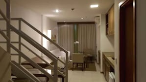 A hotel room with a staircase, a bed, a small table, and a chair. - Nobile Suites Monumental (Brasília)