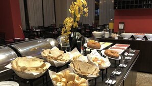 A buffet setup with various food items and utensils. - Nobile Suites Monumental (Brasília)