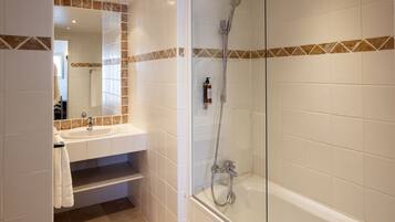 A modern bathroom with a glass-enclosed shower, a sink, and a mirror.