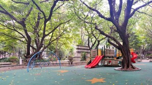 A playground with a slide, climbing structures, and a star-patterned ground. - New Pearl River (Guangzhou)