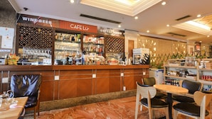 A cafe with a wine and beer section, a coffee bar, and a seating area with tables and chairs. - New Pearl River (Guangzhou)