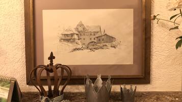A framed sketch of a building with a crown and two crowns on a countertop.