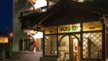 L’entrée d’un hôtel, avec une enseigne indiquant « KRONE » et « FAMILIE POHLER ».