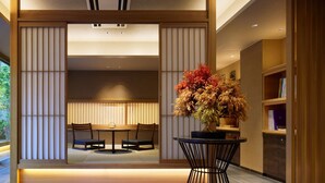 A modern interior with a dining area, a potted plant, and a bookshelf.