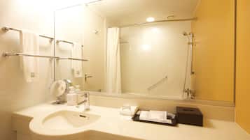 Un baño moderno con lavamanos, espejo y ducha.