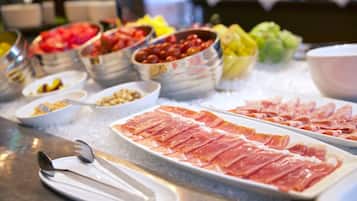 A buffet with various food items including meats and fruits.