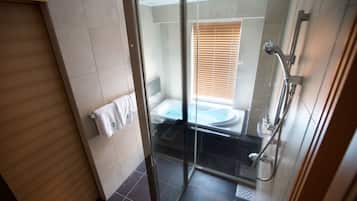 Un baño moderno con cabina de ducha de vidrio, bañera y retrete.