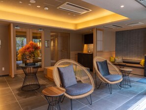 A modern interior with wicker chairs, a round table, and a sofa.