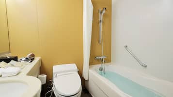 Une salle de bain équipée de toilettes, d’un bidet et d’une baignoire.