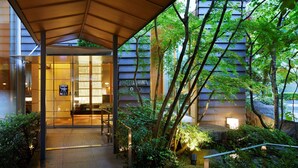 A hotel entrance with a covered walkway, glass doors, and a sign reading "HOTEL NIIWA".