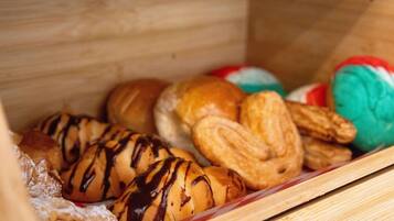 Una caja de madera con diversas pastelerías y productos de panadería.
