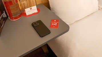 A smartphone on a table with a 'You Got the Key' sign, a bottle, and two glasses.