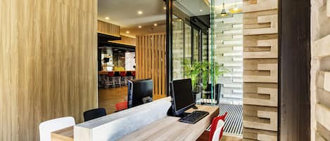 Een modern interieur met een lange tafel, stoelen en zicht op een bar.