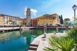 A historic square with a central fountain, a clock tower, and colorful buildings. - Hotel Sole Relax & Panorama (Riva del Garda)