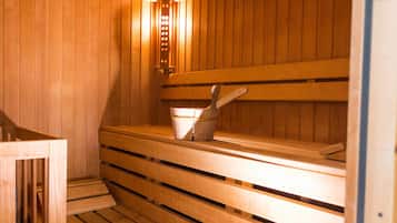 A sauna with wooden benches and a bucket.