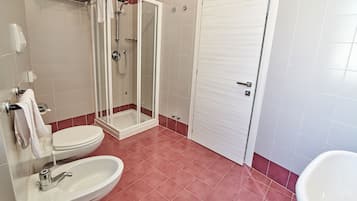 Ein Badezimmer mit einer Duschkabine, einer weißen Toilette und einem Waschbecken.
