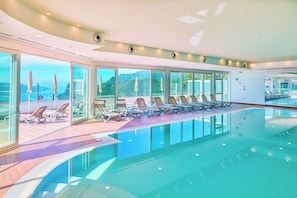 Piscine intérieure, parasols, chaises longues